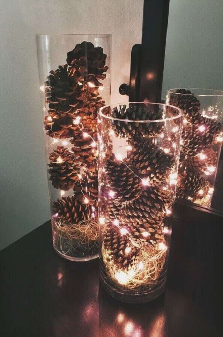 31. Ideias de decoração de Natal simples com pinhas e pisca pisca dentro de vaso de vidro – Foto: Pinterest