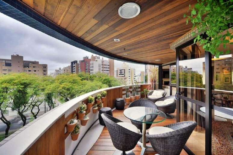81. Varanda com guarda-corpo de alvenaria decorado com pequenos vasos de flor &ndash; Foto: Bender Arquitetura