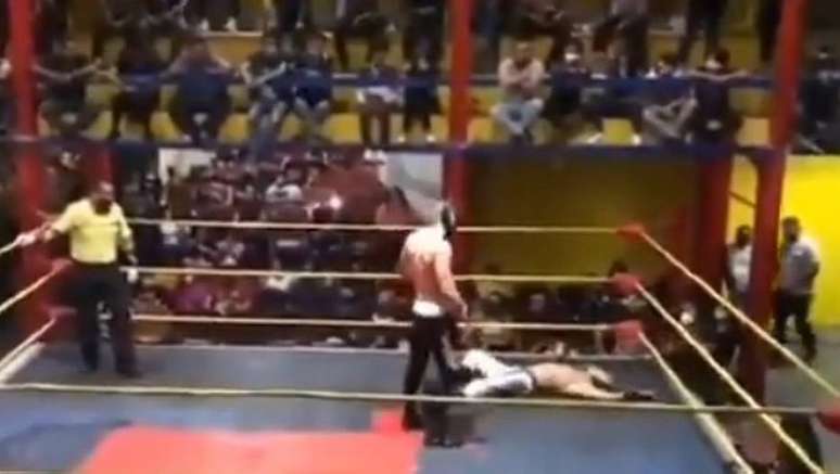 Momento em que lutador cai no ringue, após sofrer golpes seguidos no peito