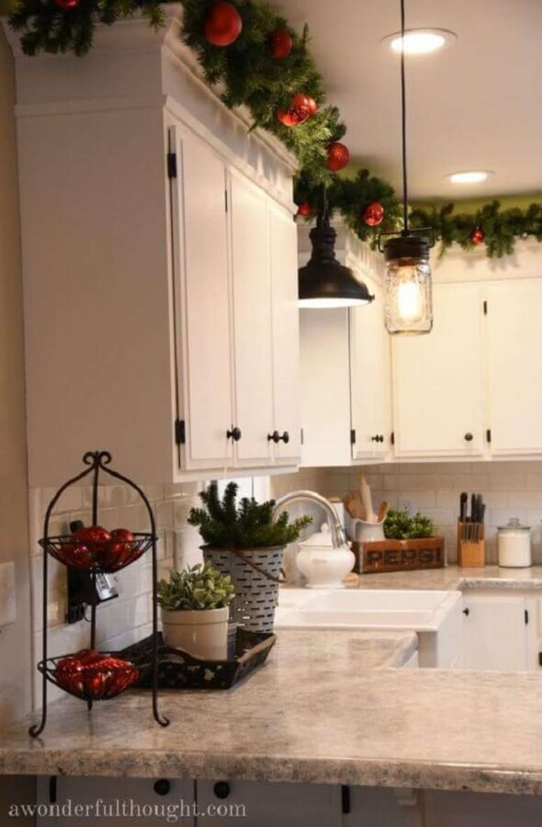 18. Decoração de cozinha com festão de Natal decorado com bolas vermelhas em cima dos armários – Foto: A Wonderful Thought