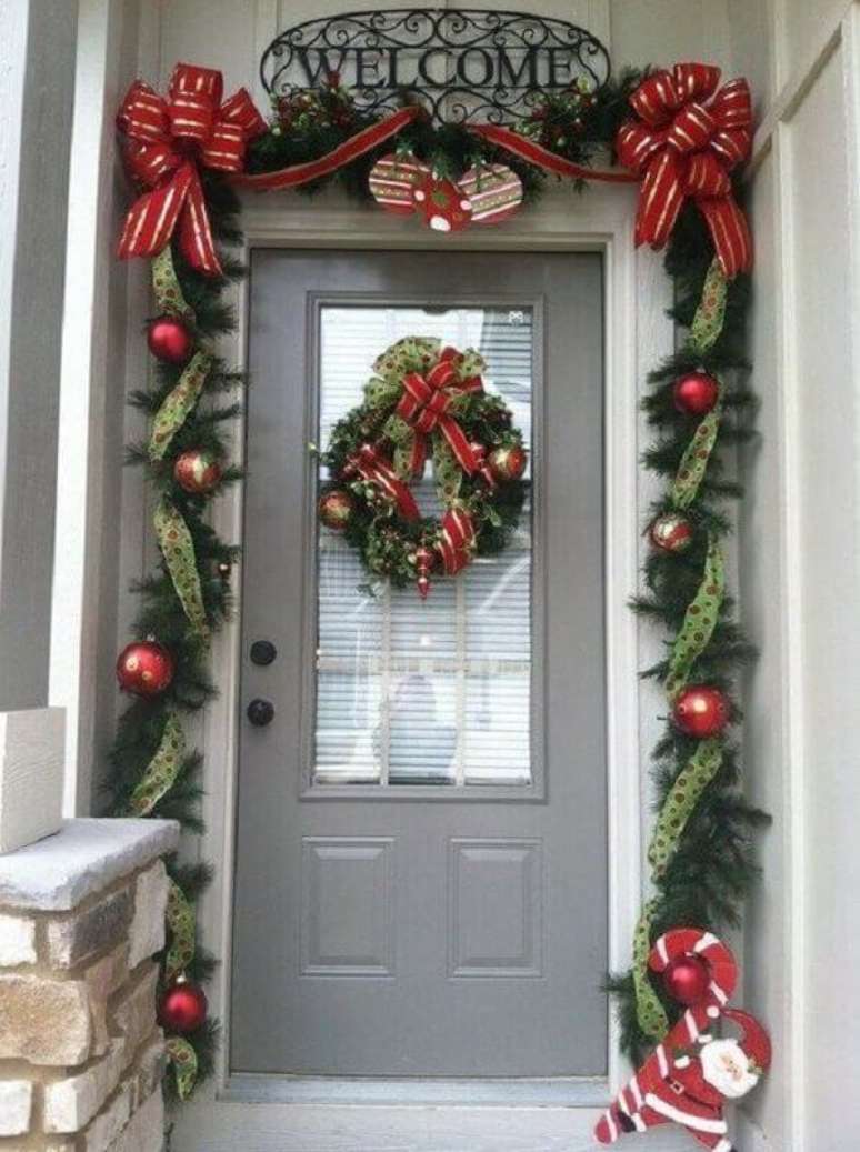 49. Fachada de casa com festão de Natal decorado com laços de fita e bolas natalinas – Foto: Pinterest