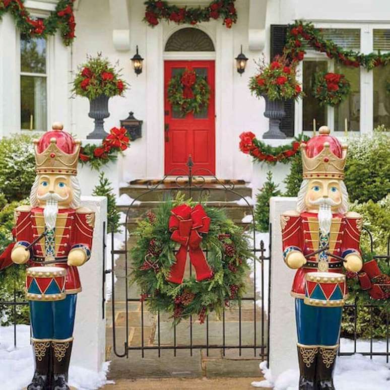 41. Linda fachada de casa decorada com vários enfeites de Natal com festão e flores vermelhas – Foto: Pinterest