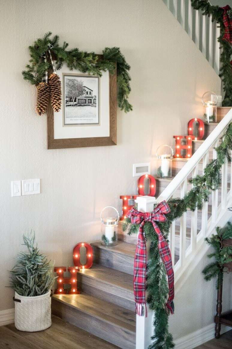 24. Decora&ccedil;&atilde;o de escada com lumin&aacute;rias de letras e enfeites de Natal com fest&atilde;o e la&ccedil;o xadrez &ndash; Foto: Elle Decor