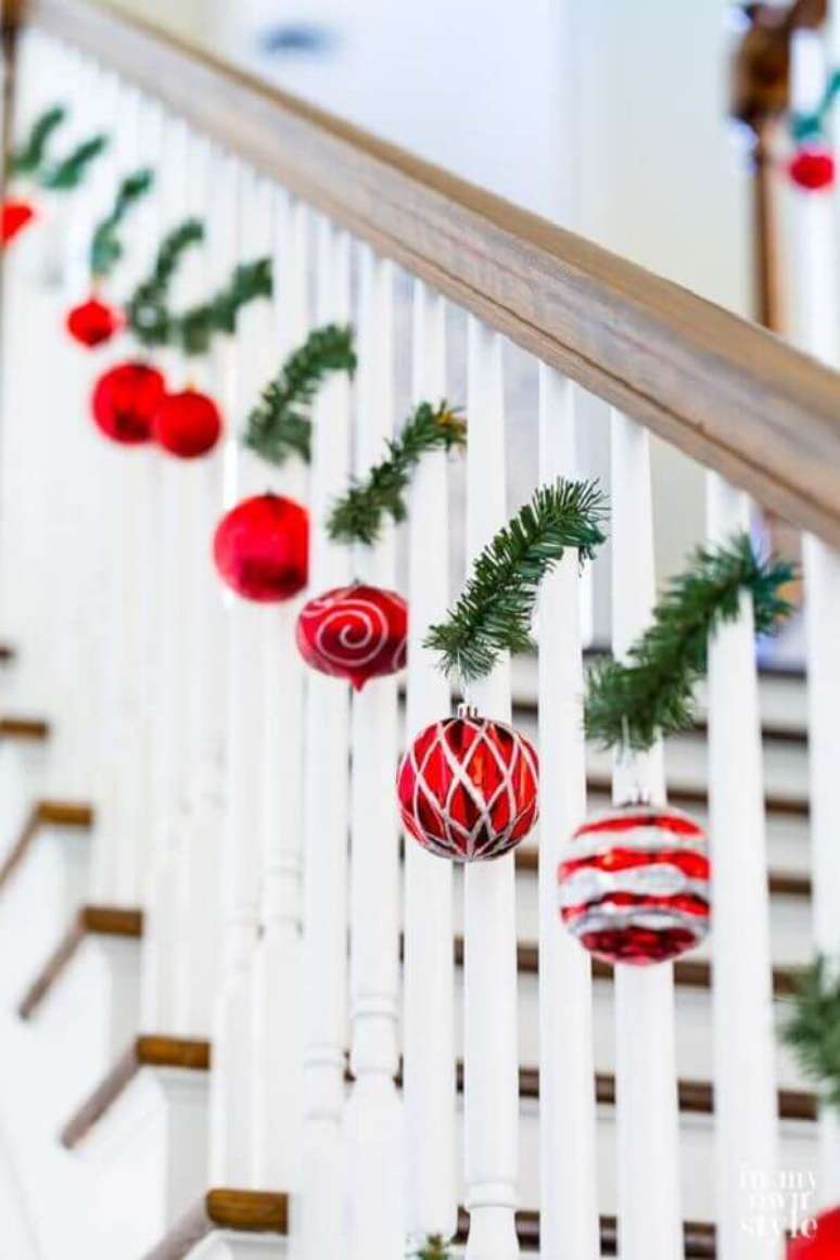33. Escada decorada com enfeites de Natal com festão e bolas vermelhas – Foto: In My Own Style