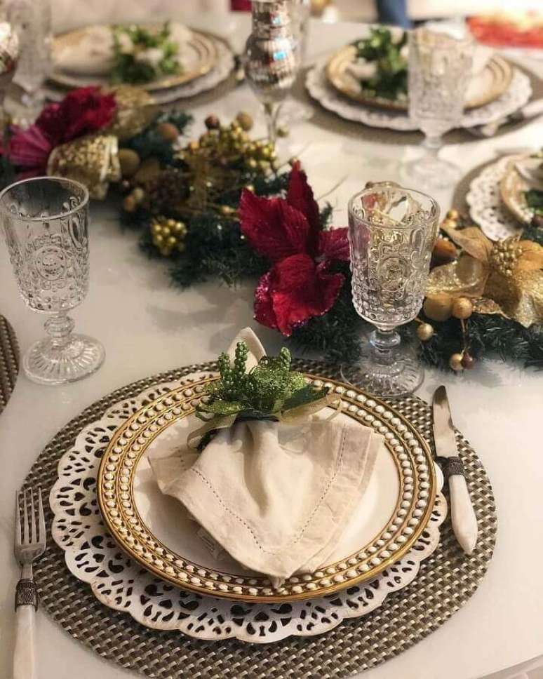23. Fest&atilde;o de Natal decorado com flores vermelhas e detalhes em dourado para mesa de natal &ndash; Foto: Pinterest