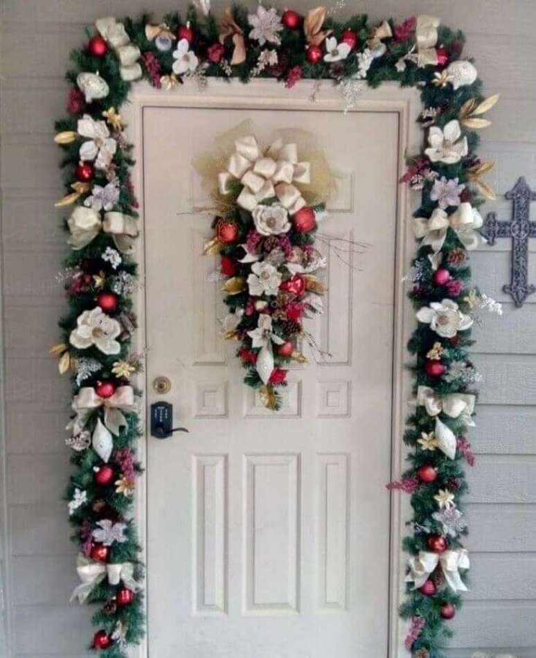 38. Porta de entrada decorada com bolas e flores para festão de Natal – Foto: Pinterest