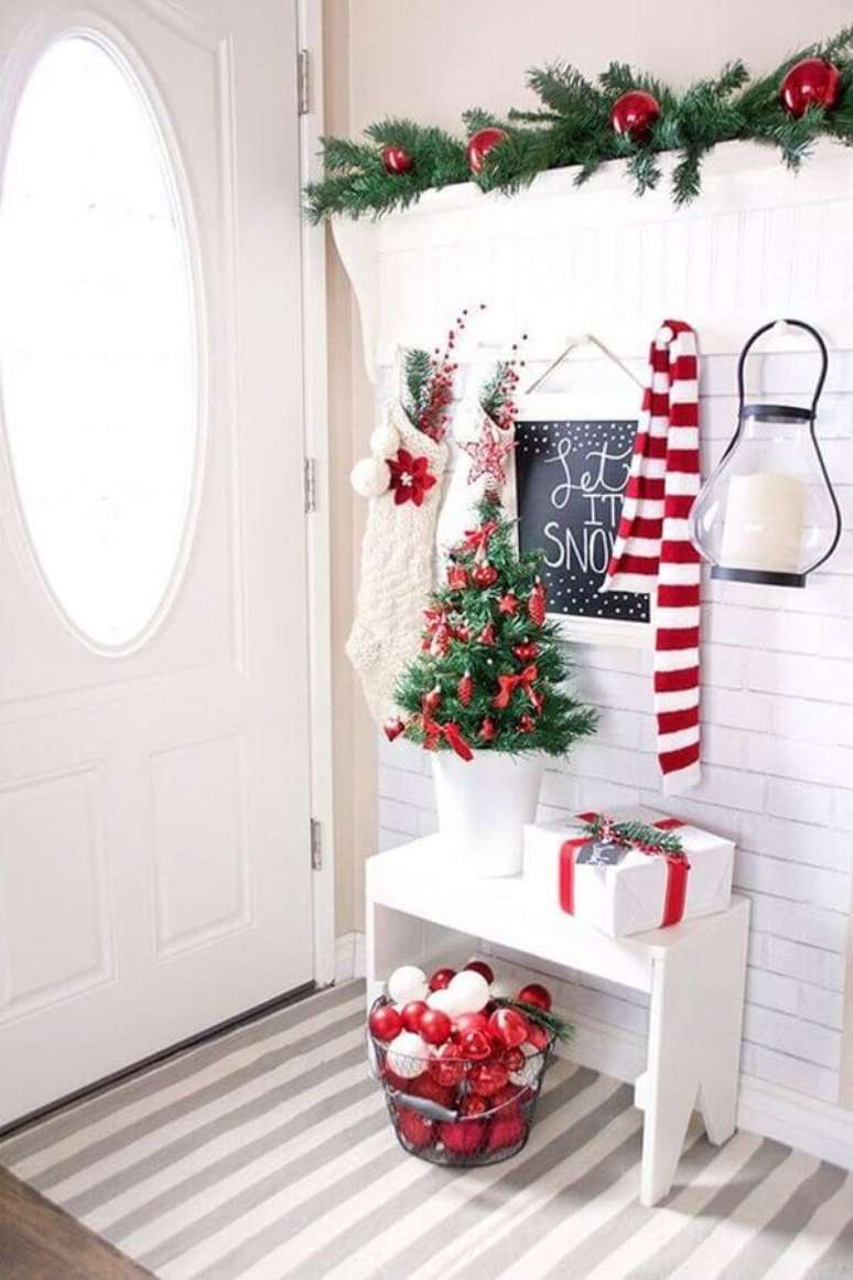 21. Hall de entrada branco decorado com festão de Natal decorado com bolas vermelhas – Foto: Archidea