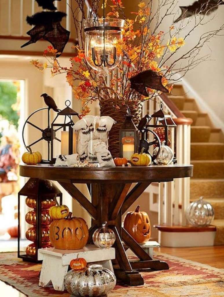 36. Corvos, abóboras de halloween de cerâmica e fantasmas decoram a mesa. Fonte: One Kindesign