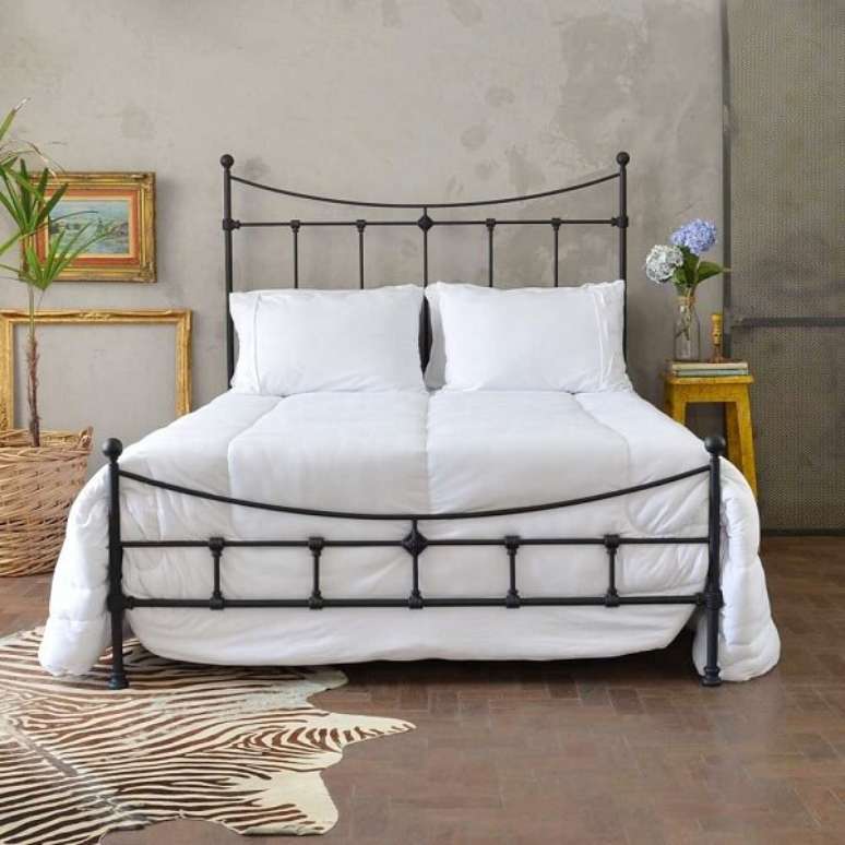 36. O jogo de cama branco se destaca sobre a cama com cabeceira de ferro. Fonte: Pinterest
