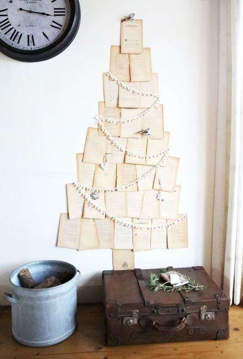 3. Folhas de livro formando árvore de natal diferente na parede – Via: Pinterest