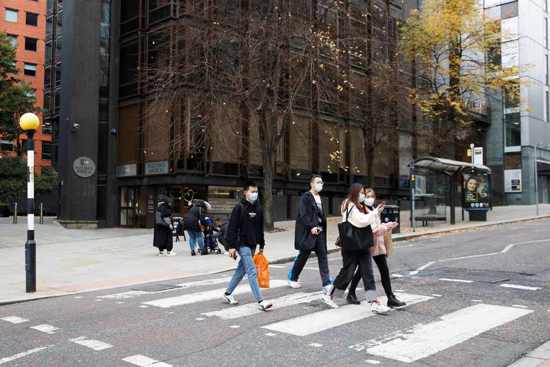 Pessoas usando máscaras atravessam rua em Manchester
19/10/2020 REUTERS/Phil Noble