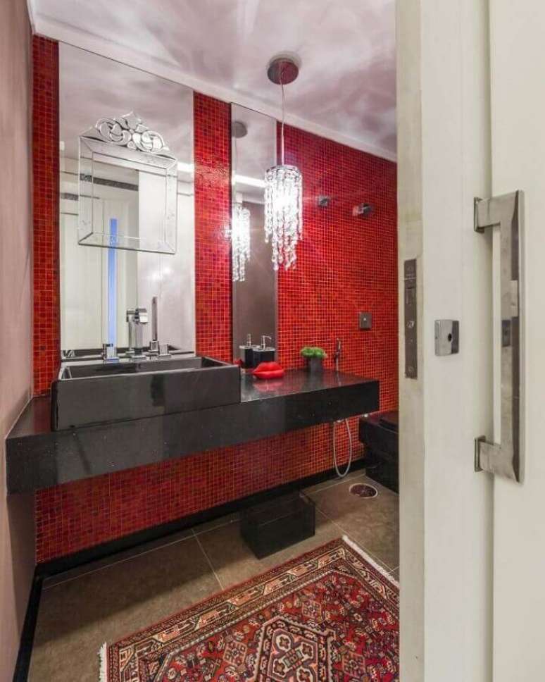 15. Bancada planejada preta para decoração de banheiro com pastilha vermelha e lustre pendente de cristal – Foto: Pinterest