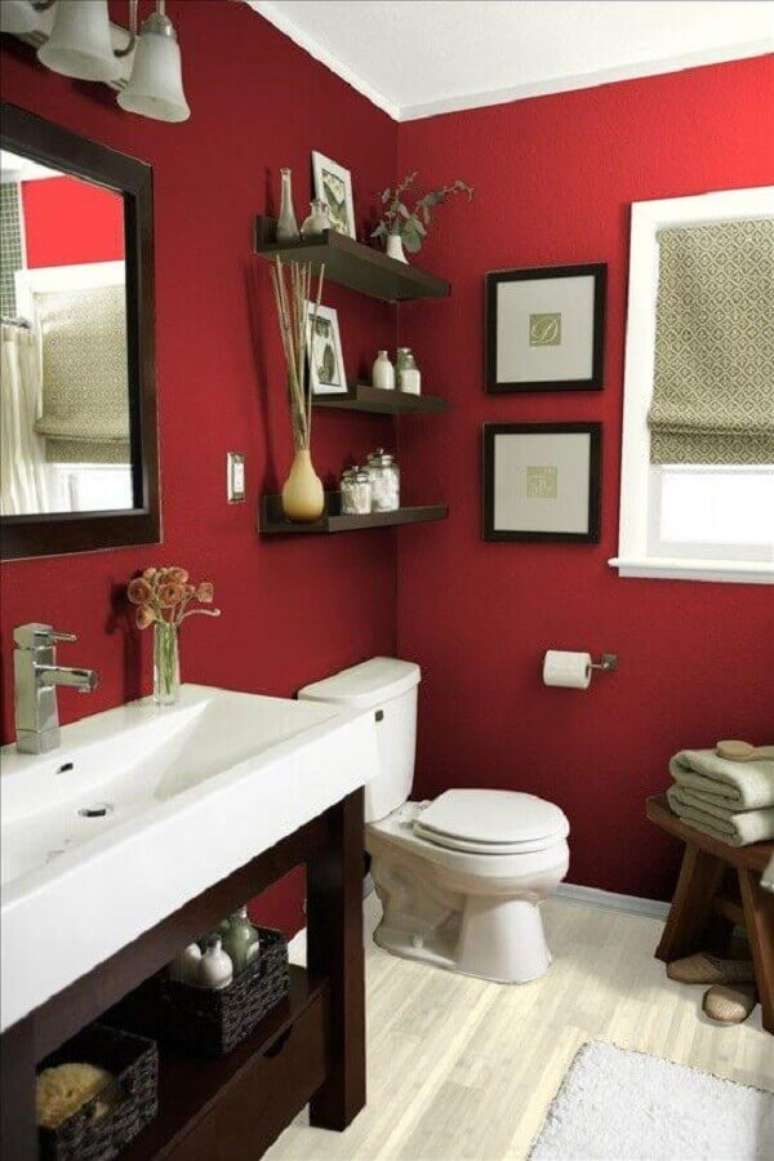 19. Banheiro vermelho decorado com prateleiras e gabinete de madeira escura – Foto: Pinterest