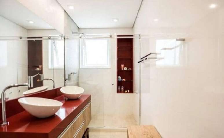 24. Banheiro vermelho e branco decorado com gabinete de madeira – Foto: L2 Arquitetura