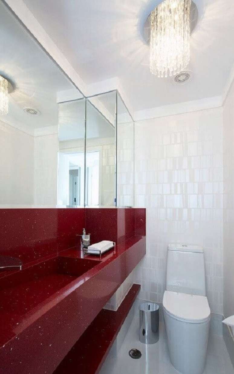 33. Lustre de cristal para decoração de banheiro pequeno vermelho e branco – Foto: Bernal Projetos
