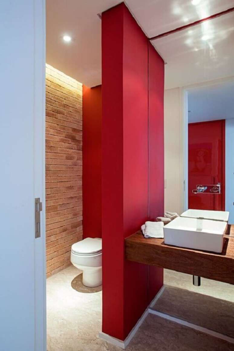 60. Parede de tijolinho e bancada de madeira para decoração de banheiro vermelho – Foto: Casa de Valentina