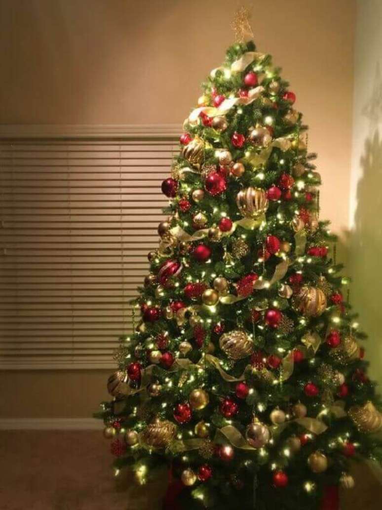 38- O pinheiro de natal foi decorado com bolas vermelhas e douradas. Fonte: kristine in between
