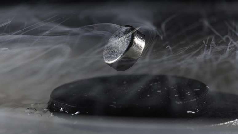 Um ímã flutua em um supercondutor resfriado com nitrogênio líquido