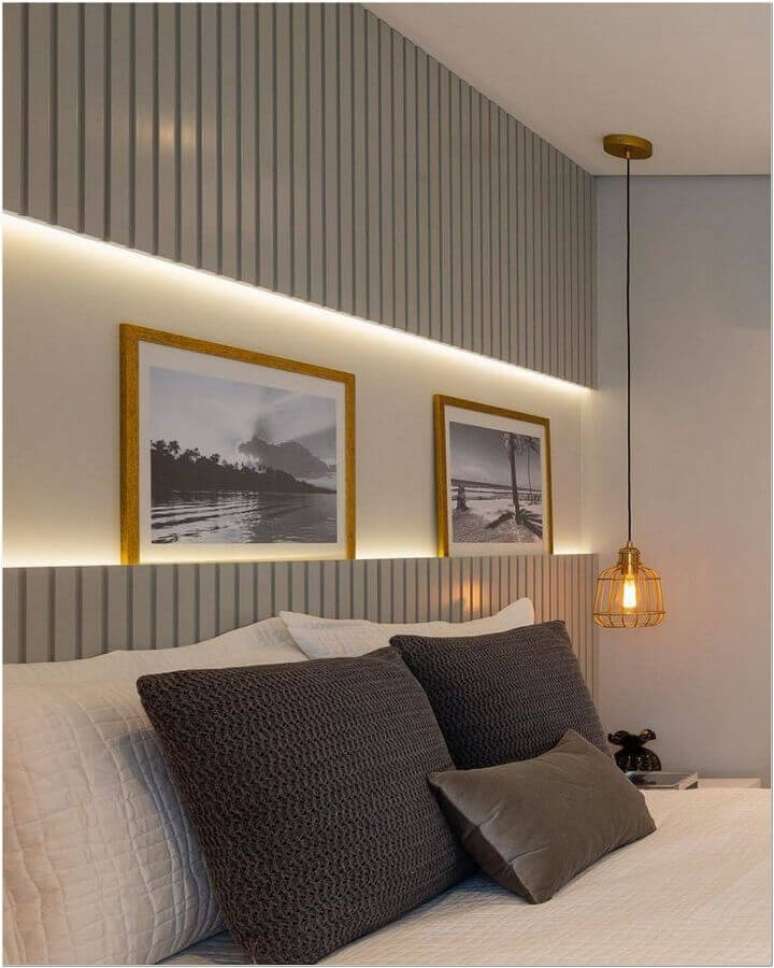 30. Decoração de quarto com cabeceira cinza de madeira e luminária pendente aramada – Foto: Jeito de Casa