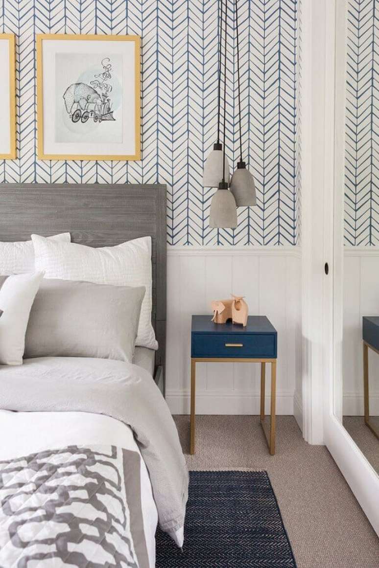 27. Quarto de casal decorado com papel de parede branco com estampa azul delicada e cabeceira de cama cinza – Foto: Fashionismo