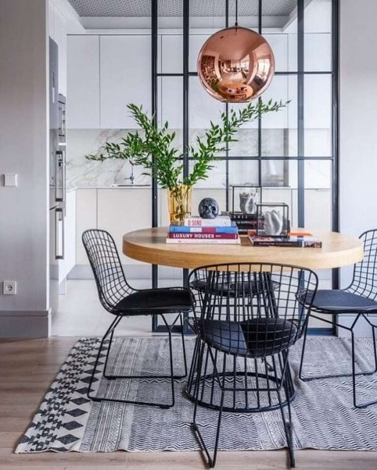 7. Sala de jantar sofisticada com mesa redonda e cadeira Bertoia preta. Fonte: Pinterest