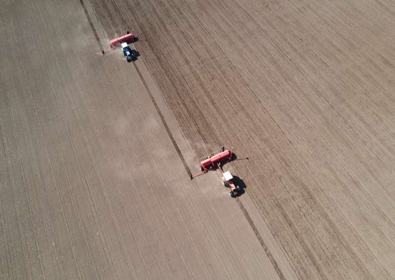 Agricultural workers operate tractors with seeders to sow soybeans in the field near the village of Husachivka in Kiev region, Ukraine April 17, 2020. REUTERS/Anton Muraviov