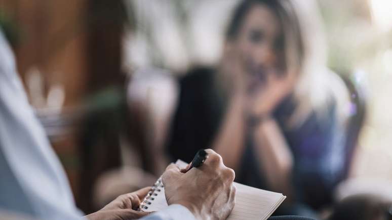 mulher em terapia, terapeuta tomando notas