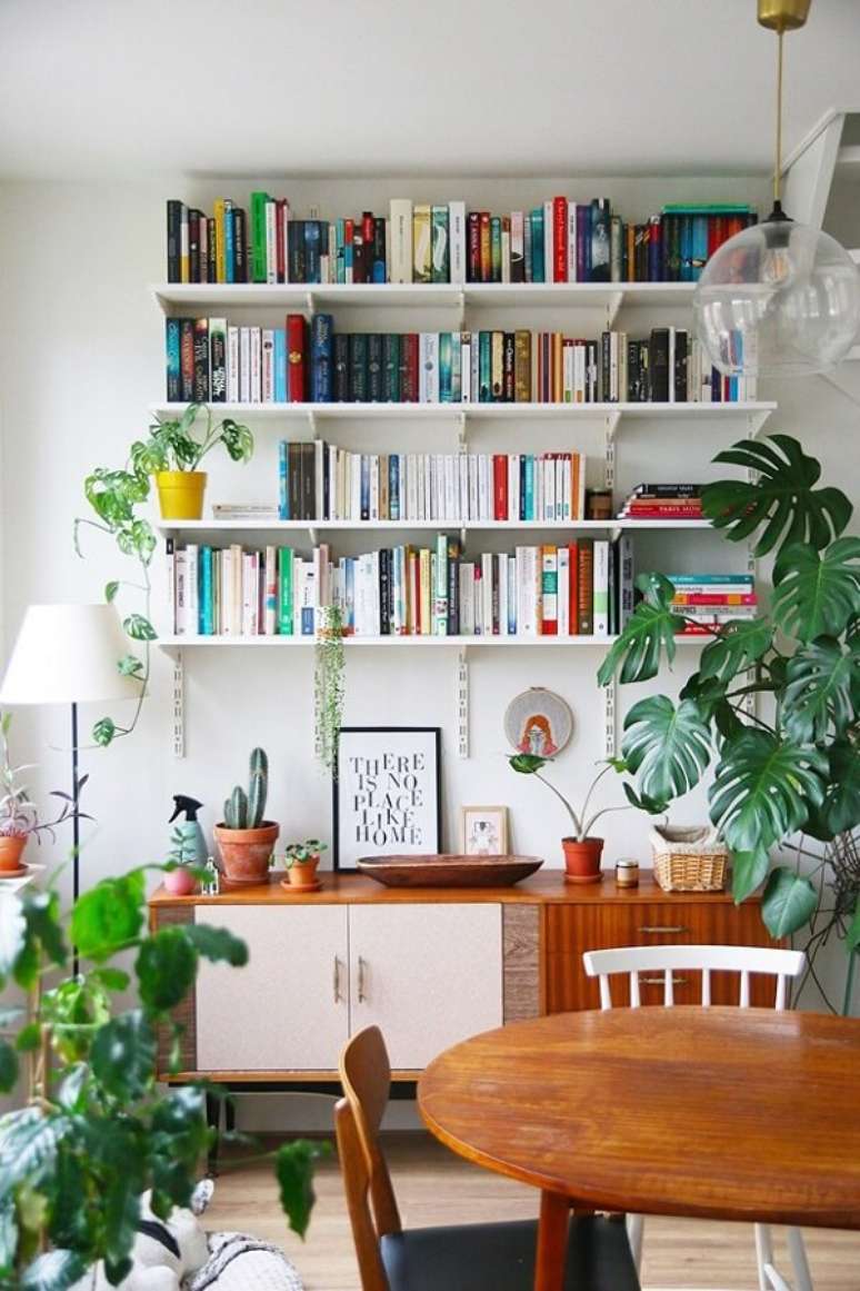 42. O verde das plantas traz um toque especial para o ambiente com estante para sala branca. Fonte: Casa Vogue