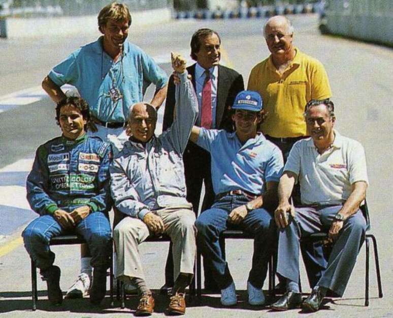 Encontro de campe&otilde;es: Senna reverencia Fangio, cercados pelos campe&otilde;es James Hunt, Jackie Stewart, Denny Hulme (em p&eacute;), Piquet e Brabham (sentados).