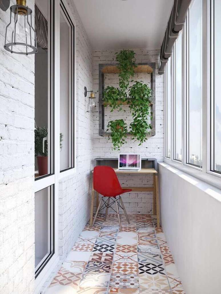 30. Decoração com piso hidráulico e plantas para varanda pequena com home office – Foto: Reciclar e Decorar