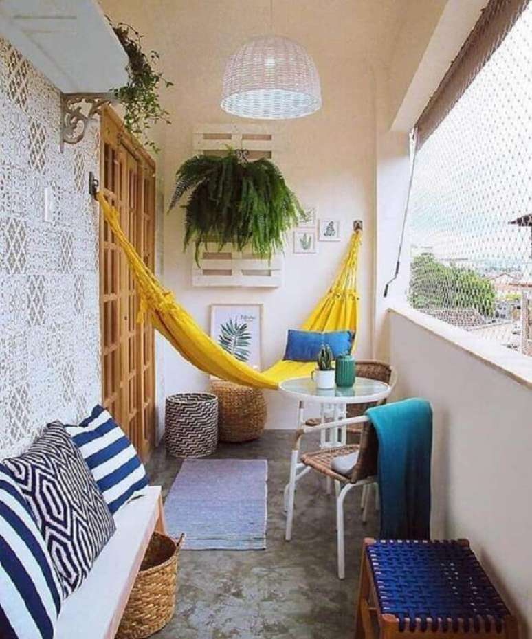 43. Decoração com rede amarela e plantas para varanda com sombra – Foto: Jeito de Casa