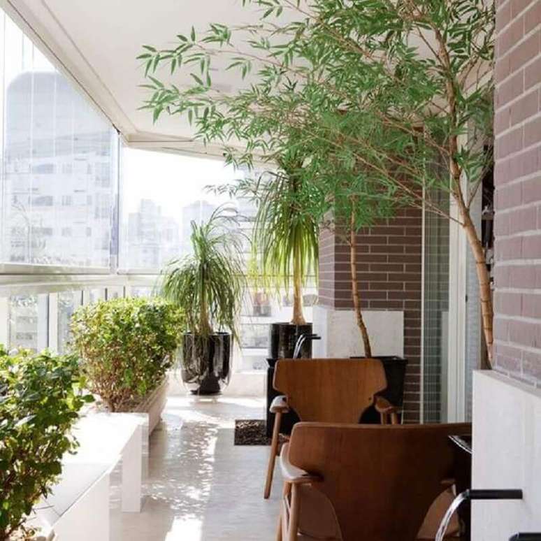 49. Vasos de plantas para varanda de apartamento com poltronas de madeira – Foto: Pinterest