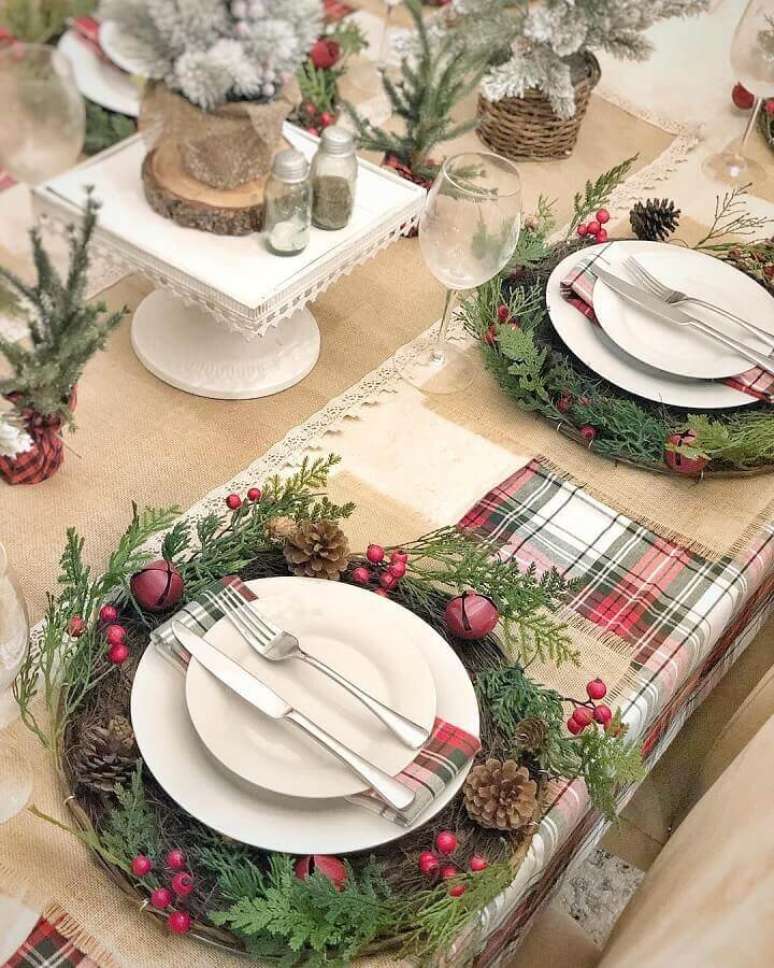 16. Arranjos de Natal para mesa com pinhas e guirlanda ao redor dos pratos decorados com guardanapos xadrez – Foto: Rustic & Woven