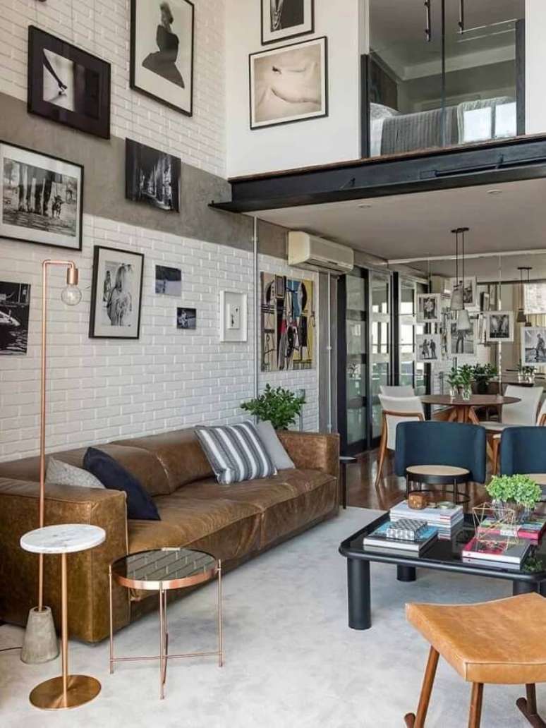 28. Sala moderna decorada com vários quadros preto e branco e sofá de couro marrom – Foto: JA Interiores