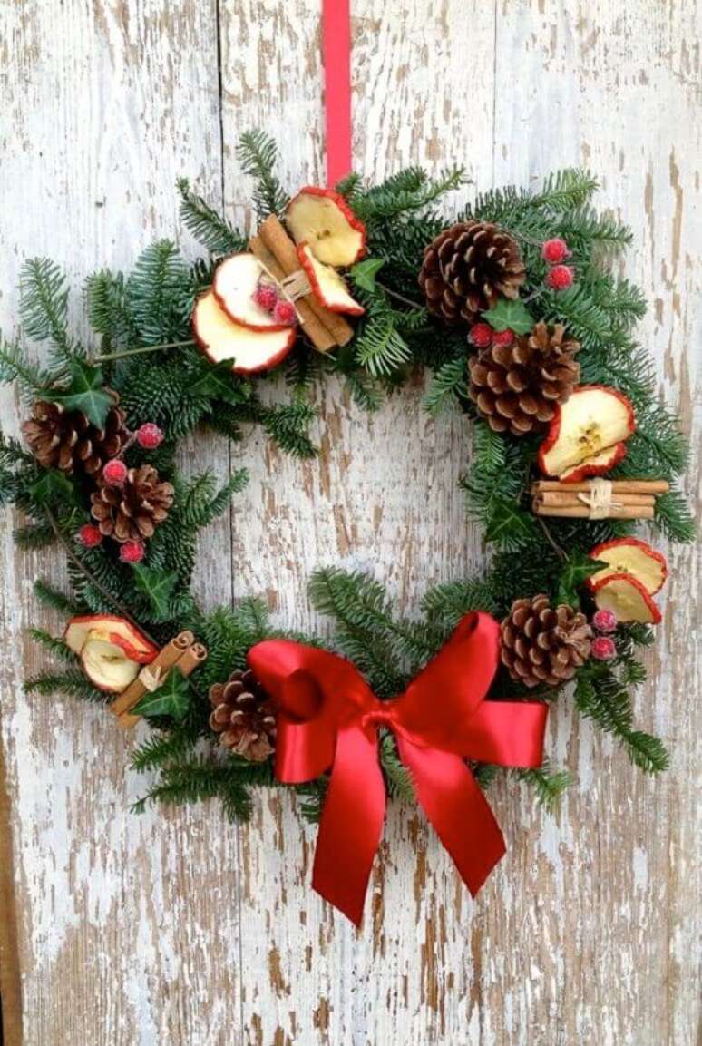 57. Linda guirlanda de Natal com pinhas e laço vermelho – Foto: Christmas Glitter