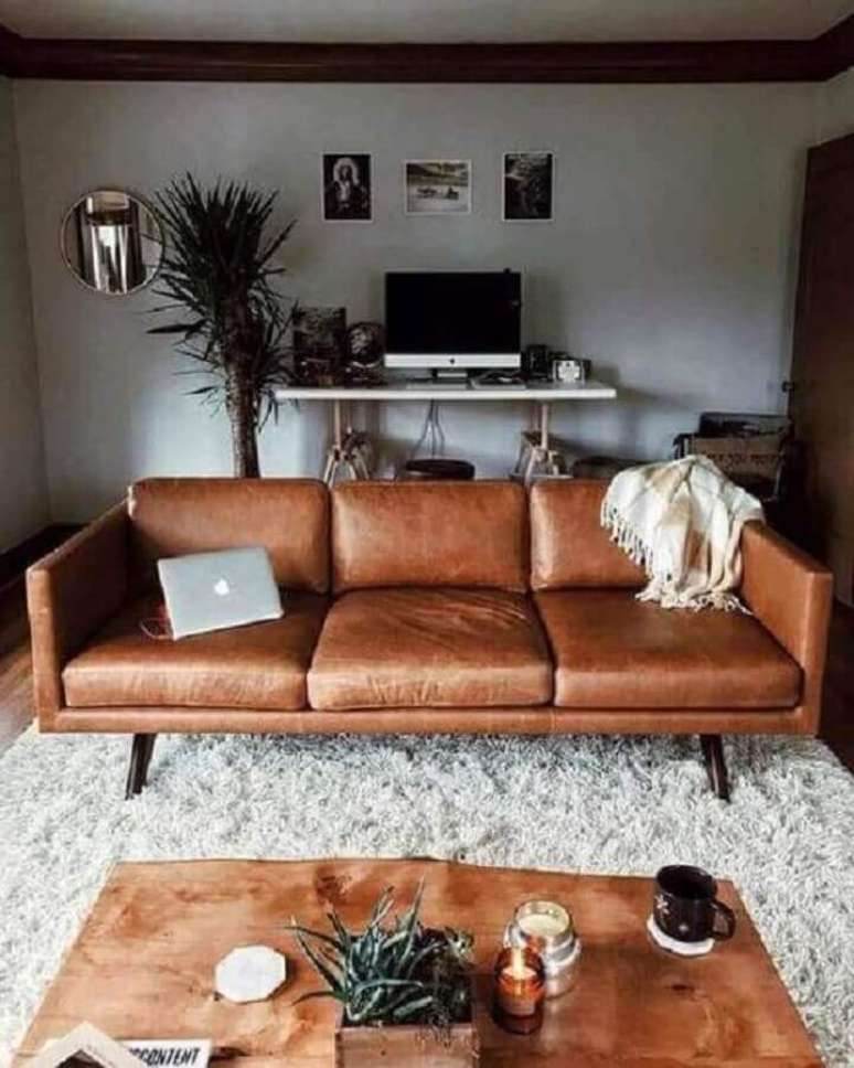 62. Sofá de couro marrom para decoração de sala cinza com tapete felpudo – Foto: Apartment Therapy