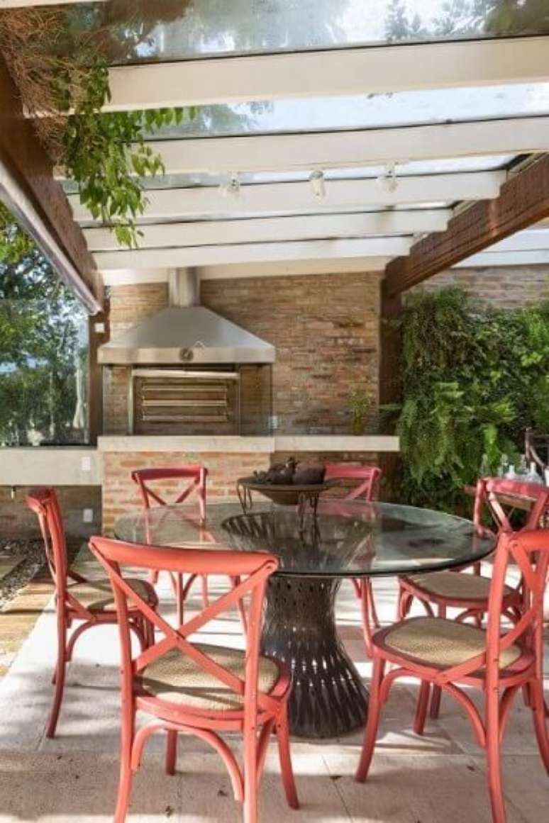 22. Varanda com mesa de jantar preta e cadeiras vermelhas – Via: Kali Arquitetura