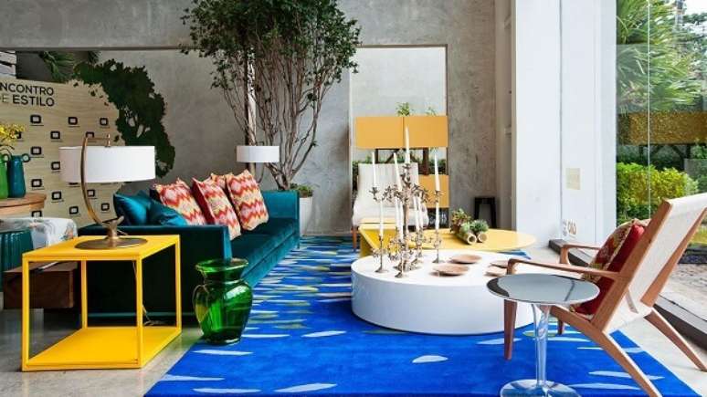 57. A mesa de centro redonda branca sobre o tapete azul equilibra as cores na sala. Projeto por Bruno Carvalho