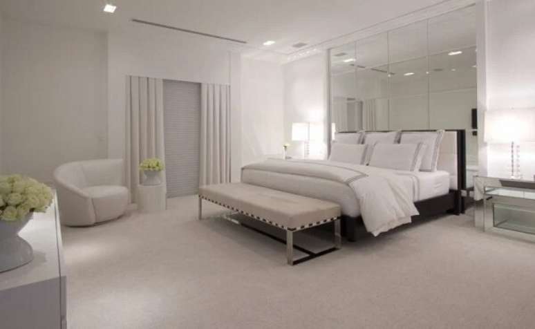 16. O espelho quadrado para quarto preenche toda a parede da cabeceira da cama. Fonte: Christina Hamoui