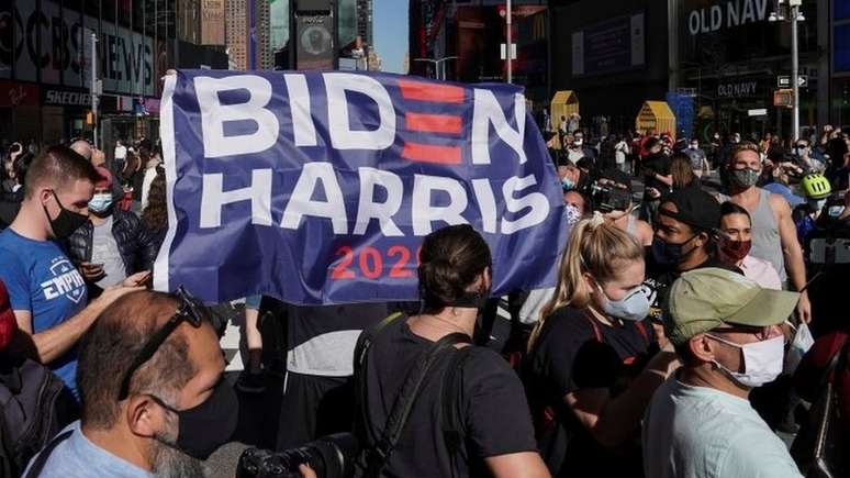 Simpatizantes de Joe Biden comemoram em Nova York, neste sábado; sistema eleitoral do país é indireto