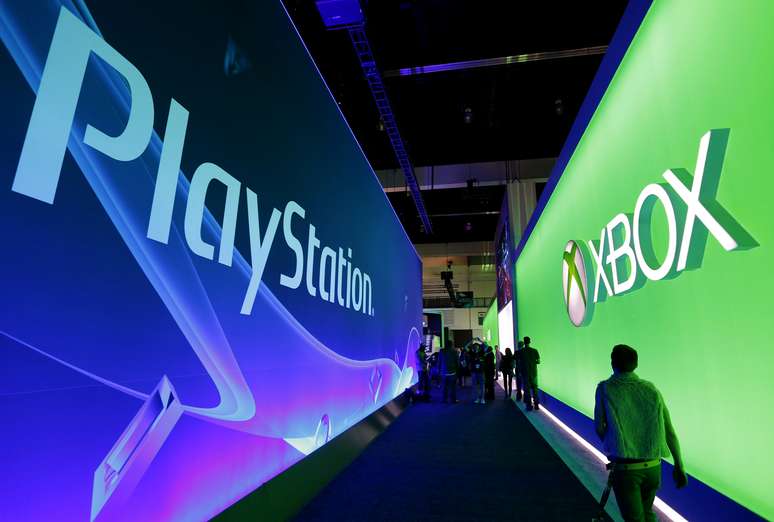 Pessoas passam em corredor com paineis do Playstation e do Xbox booths durante eventos de games em Los Angeles. 10/6/2014.  REUTERS/Jonathan Alcorn 