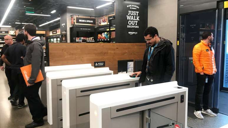 Consumidores entram em uma loja Amazon Go através de um aplicativo em seus smartphones