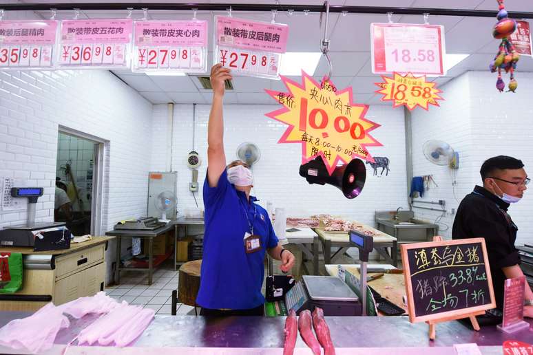 Funcion&aacute;rio coloca placa de pre&ccedil;o da carne su&iacute;na em supermercado de Hangzhou, na China. China Daily via REUTERS  