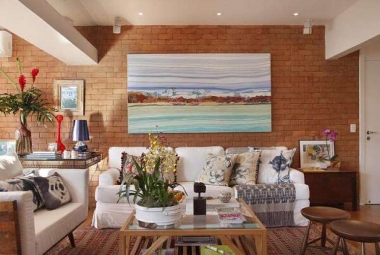 42. O quadro colorido faz o contraste perfeito com a parede de tijolinho. Projeto de Escala Arquitetura