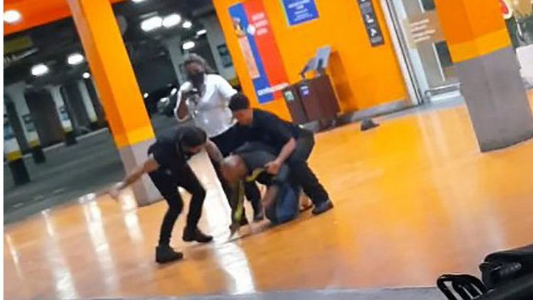 Imagem de agressão no Carrefour, com três funcionários ao redor de homem; caso está sendo comparado com o de George Floyd, sufocado por policiais nos EUA