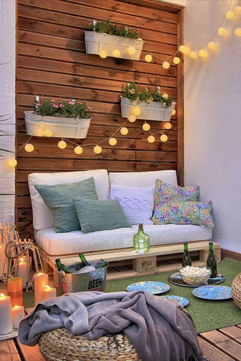 32. Poltrona de pallet para varanda com luzes charmosas – Via: Love Property