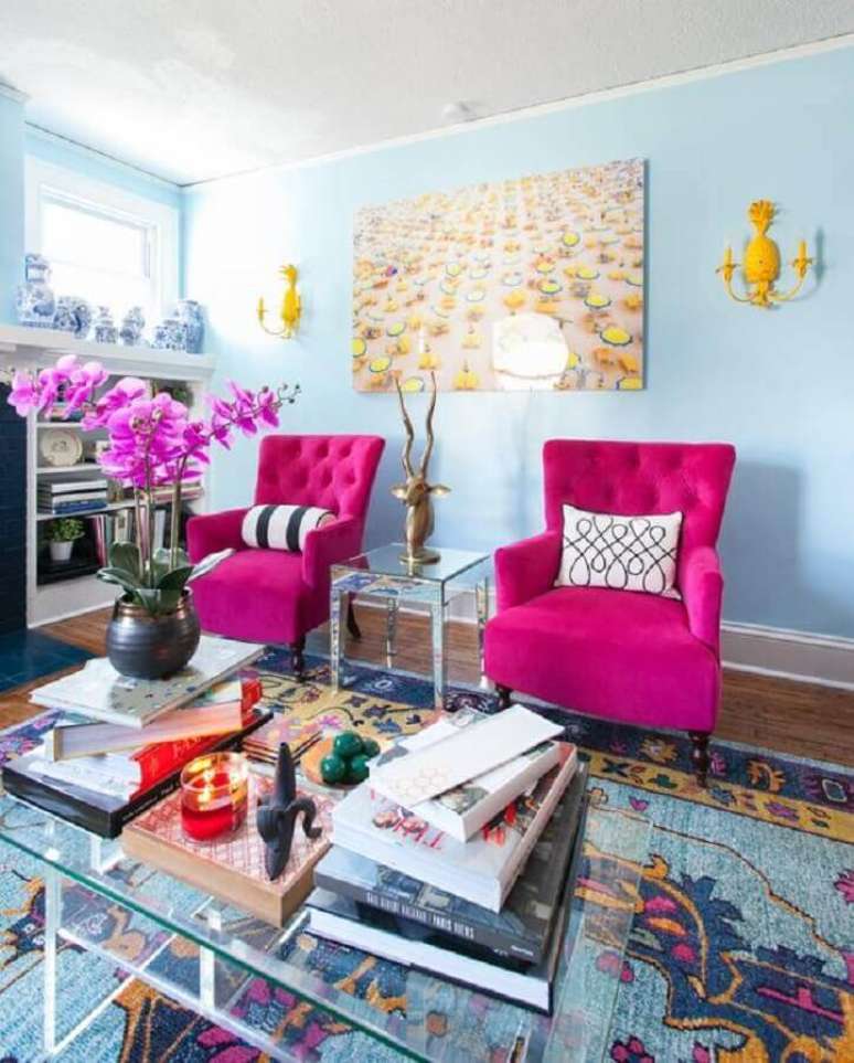 46. Sala azul decorada com mesa de centro de vidro e poltrona rosa pink &ndash; Foto: Apartment Therapy