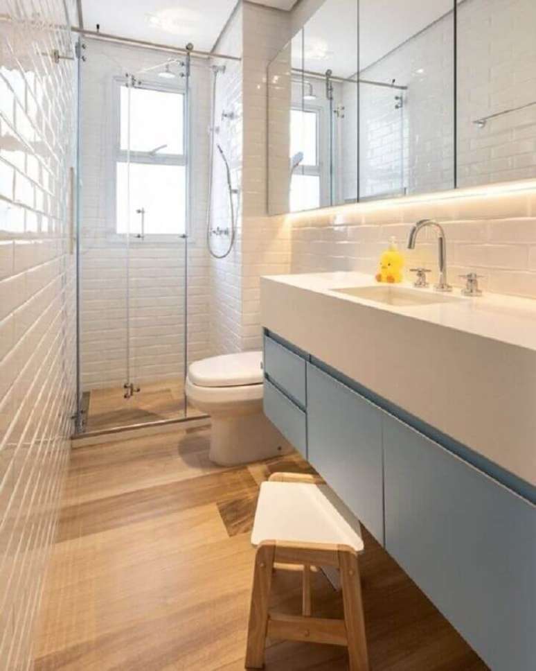 22. Decoração de banheiro sob medida pequeno com piso de madeira e gabinete suspenso azul claro – Foto: Pinterest