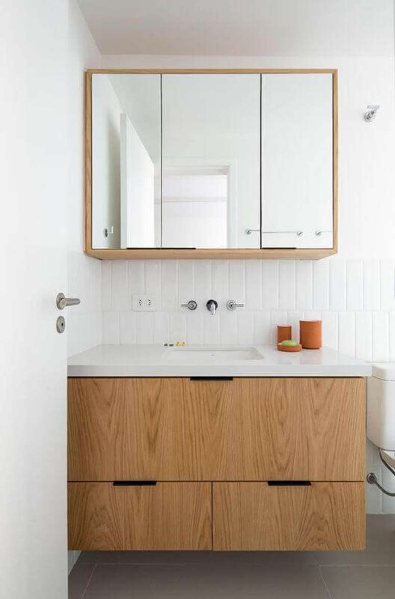 3. Decoração clean com armário de banheiro sob medida pequeno de madeira – Foto: INÁ Arquitetura