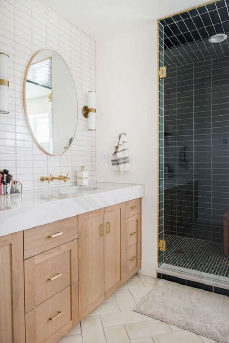 26. Decoração com espelho redondo e gabinete de madeira para banheiro sob medida – Foto: Apartment Therapy